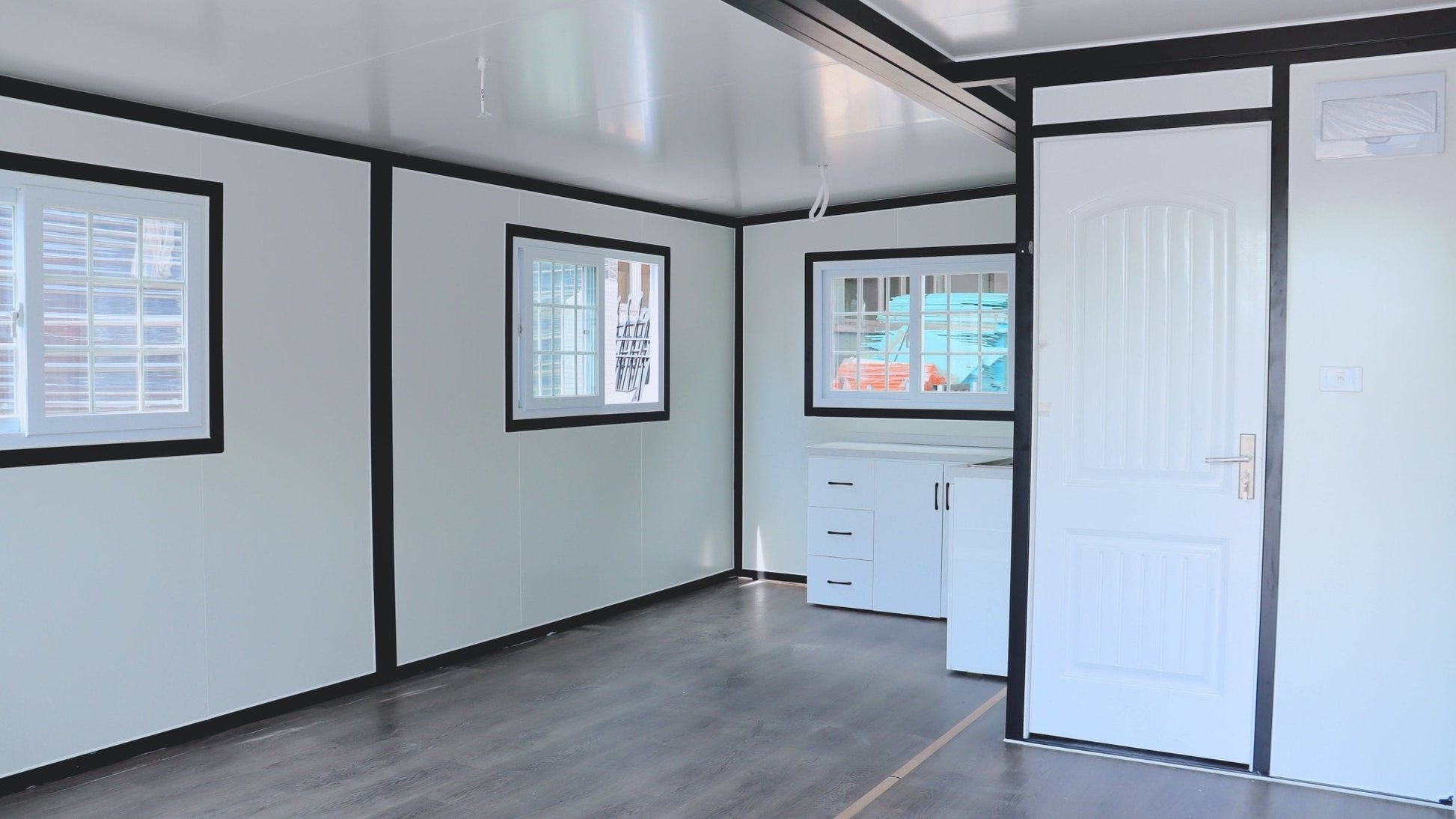 Exterior view of 2-bedroom deluxe folding house

Modern prefabricated orange modular home

Inside view of compact folding prefab unit

Kitchen area with electric setup in prefab home

Folding house with porch roof kit variant