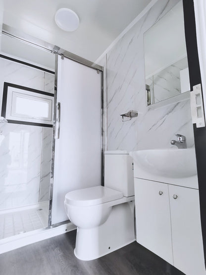 Exterior view of 2-bedroom deluxe folding house

Modern prefabricated orange modular home

Inside view of compact folding prefab unit

Kitchen area with electric setup in prefab home

Folding house with porch roof kit variant