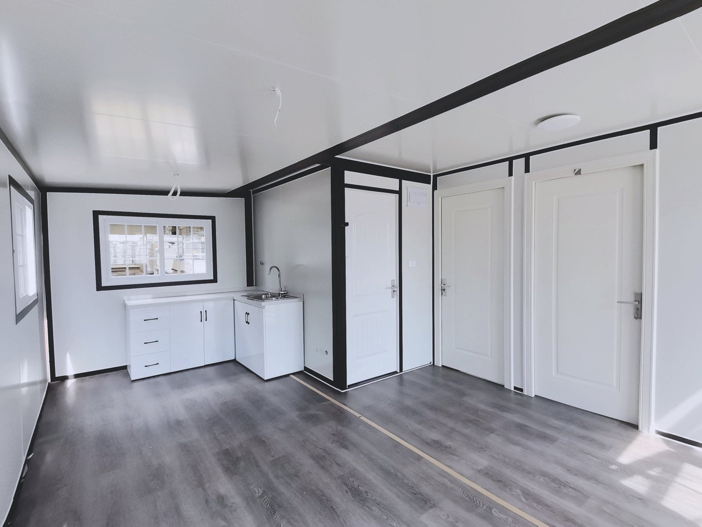 Exterior view of 2-bedroom deluxe folding house

Modern prefabricated orange modular home

Inside view of compact folding prefab unit

Kitchen area with electric setup in prefab home

Folding house with porch roof kit variant