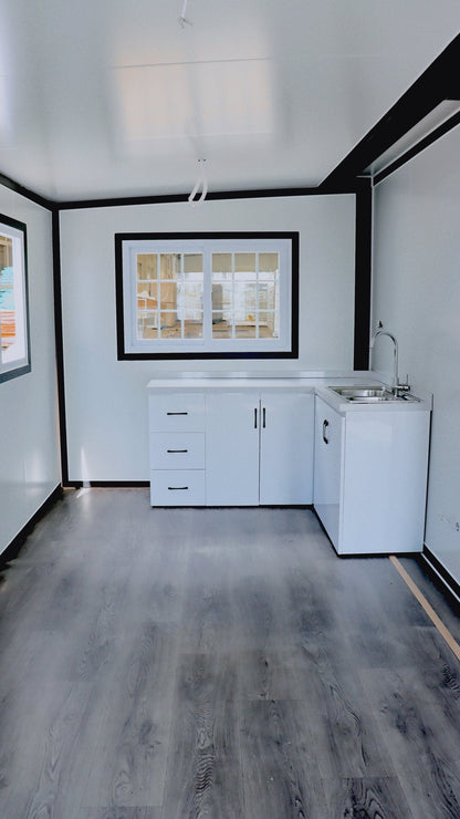 Exterior view of 2-bedroom deluxe folding house

Modern prefabricated orange modular home

Inside view of compact folding prefab unit

Kitchen area with electric setup in prefab home

Folding house with porch roof kit variant