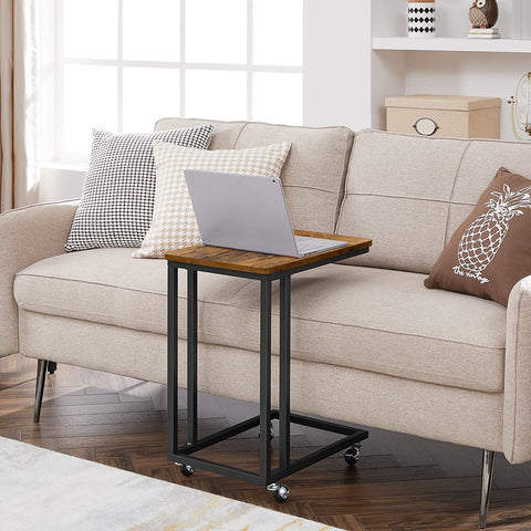 Rustic side table with laptop on top near sofa
Rolling wood TV tray with black metal legs
End table with wheels next to couch
Industrial-style side table for laptop and coffee