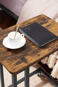 Rustic side table with laptop on top near sofa
Rolling wood TV tray with black metal legs
End table with wheels next to couch
Industrial-style side table for laptop and coffee