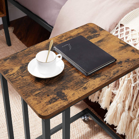 Rustic side table with laptop on top near sofa
Rolling wood TV tray with black metal legs
End table with wheels next to couch
Industrial-style side table for laptop and coffee