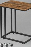 Rustic side table with laptop on top near sofa
Rolling wood TV tray with black metal legs
End table with wheels next to couch
Industrial-style side table for laptop and coffee