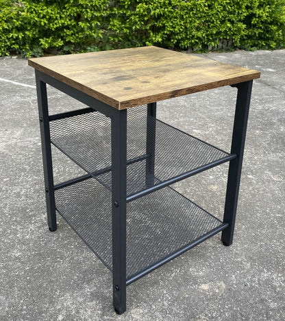 Rustic end tables in a cozy living room setting with sofa and lamp

Side View: Square wood top table with black mesh shelf

Angled View: Rustic wood and black metal table with adjustable shelf

Front View: Front profile of industrial end table with wood top and mesh shelf

Top View: Close-up of wood grain tabletop with rounded edges