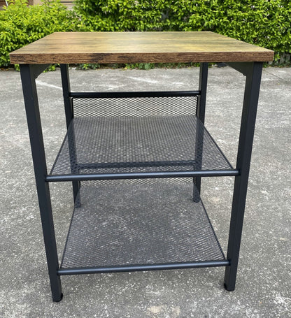 Rustic end tables in a cozy living room setting with sofa and lamp

Side View: Square wood top table with black mesh shelf

Angled View: Rustic wood and black metal table with adjustable shelf

Front View: Front profile of industrial end table with wood top and mesh shelf

Top View: Close-up of wood grain tabletop with rounded edges