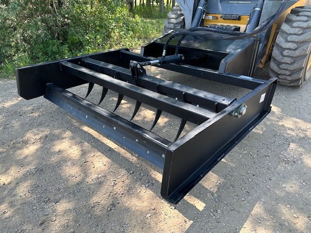 Skid Steer 72" Hydraulic Box Blade Leveler side view
Box grader with hydraulic rippers engaged
Attachment leveling gravel with skid steer
Close-up of pillow block bearings and rippers
Fully mounted box blade in action