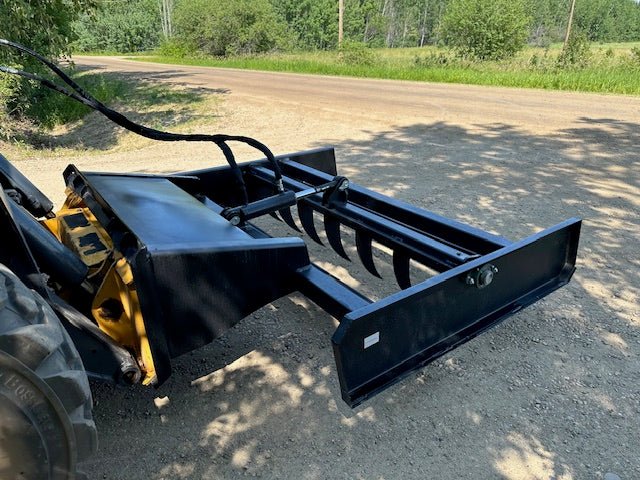 Skid Steer 72" Hydraulic Box Blade Leveler side view
Box grader with hydraulic rippers engaged
Attachment leveling gravel with skid steer
Close-up of pillow block bearings and rippers
Fully mounted box blade in action