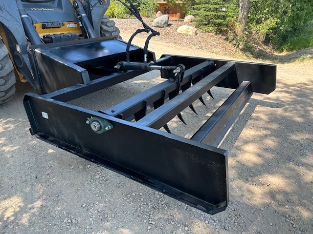Skid Steer 72" Hydraulic Box Blade Leveler side view
Box grader with hydraulic rippers engaged
Attachment leveling gravel with skid steer
Close-up of pillow block bearings and rippers
Fully mounted box blade in action