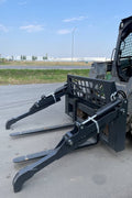 Front view of skid steer pipe grapple with clamp arms
Side view showing 48-inch clamp arm forks in use
Pipe grapple lifting construction material
Close-up of dual hydraulic clamp system