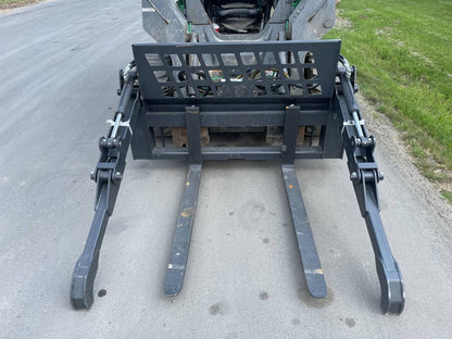 Front view of skid steer pipe grapple with clamp arms
Side view showing 48-inch clamp arm forks in use
Pipe grapple lifting construction material
Close-up of dual hydraulic clamp system