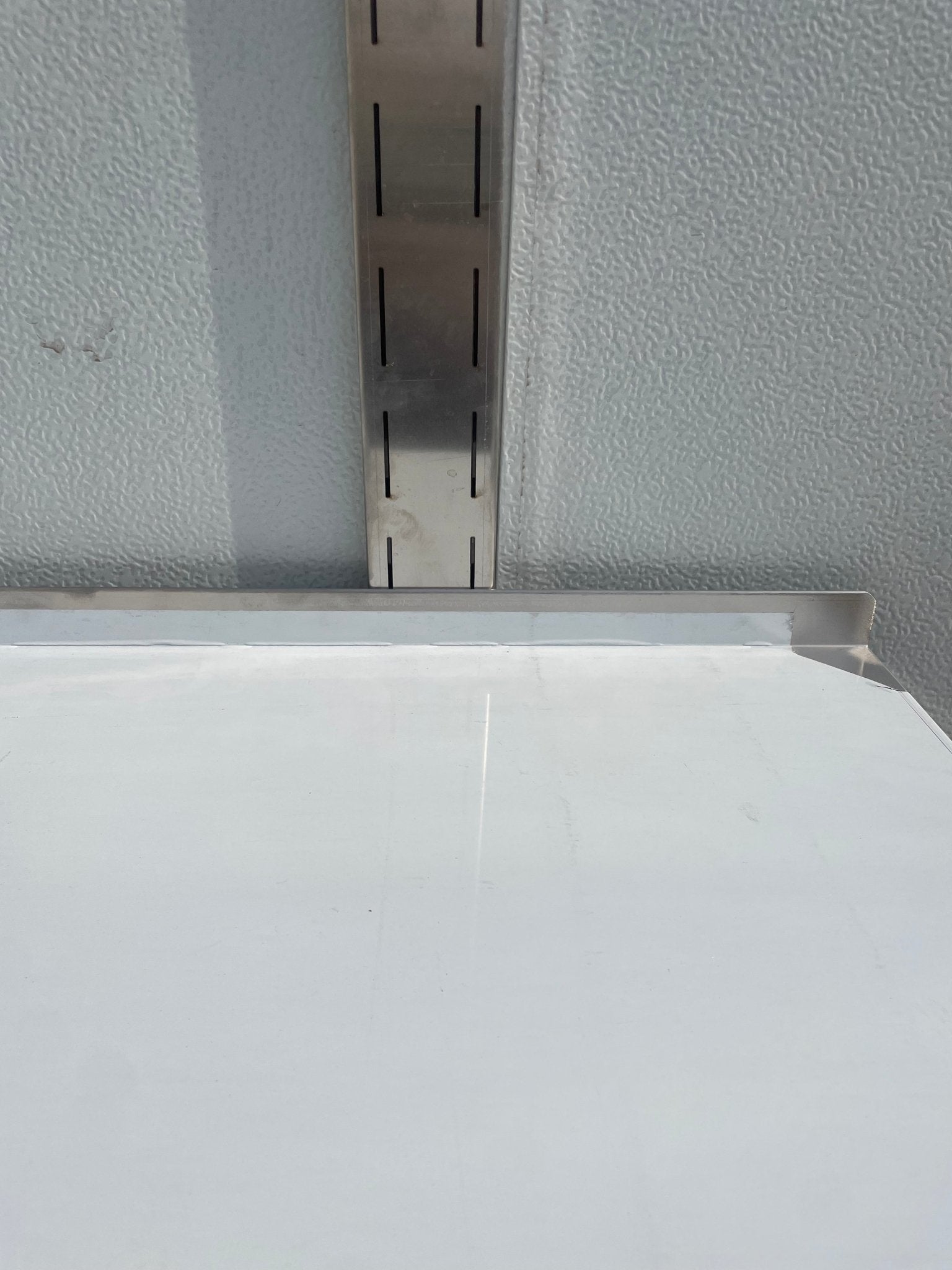Stainless steel wall-mounted shelf front view

Close-up of shelf bracket and mounting

Side view of stainless steel shelf over prep station

Commercial wall shelf above kitchen counter

Single-tier wall shelf with polished finish