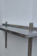 Stainless steel wall-mounted shelf front view

Close-up of shelf bracket and mounting

Side view of stainless steel shelf over prep station

Commercial wall shelf above kitchen counter

Single-tier wall shelf with polished finish