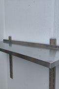 Stainless steel wall-mounted shelf front view

Close-up of shelf bracket and mounting

Side view of stainless steel shelf over prep station

Commercial wall shelf above kitchen counter

Single-tier wall shelf with polished finish