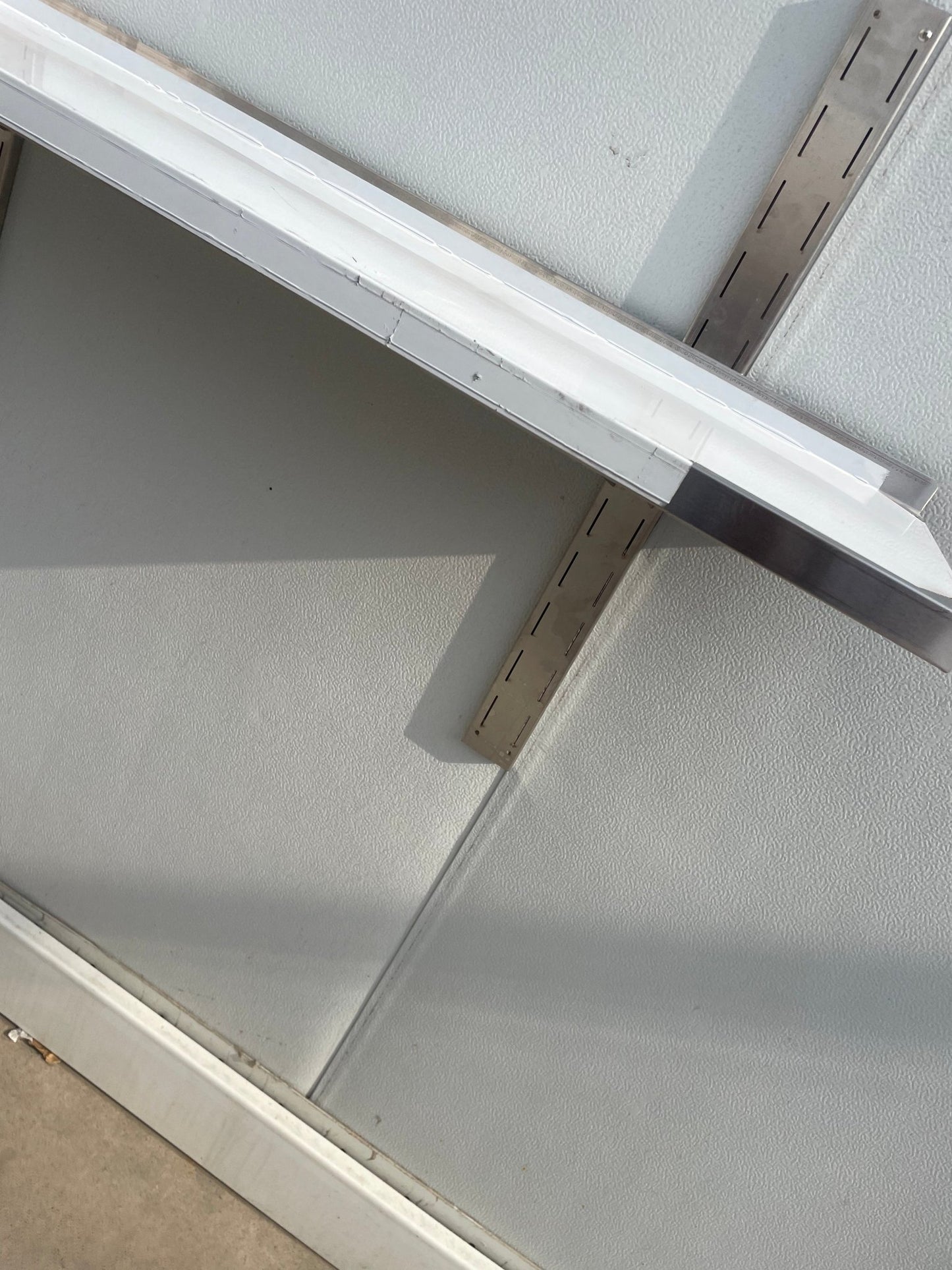 Stainless steel wall-mounted shelf front view

Close-up of shelf bracket and mounting

Side view of stainless steel shelf over prep station

Commercial wall shelf above kitchen counter

Single-tier wall shelf with polished finish
