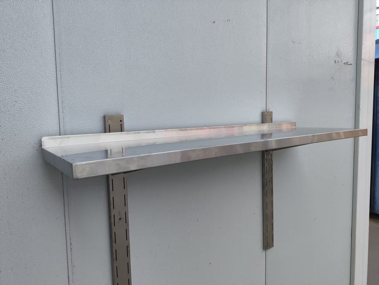 Stainless steel wall-mounted shelf front view

Close-up of shelf bracket and mounting

Side view of stainless steel shelf over prep station

Commercial wall shelf above kitchen counter

Single-tier wall shelf with polished finish