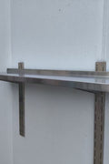 Stainless steel wall-mounted shelf front view

Close-up of shelf bracket and mounting

Side view of stainless steel shelf over prep station

Commercial wall shelf above kitchen counter

Single-tier wall shelf with polished finish