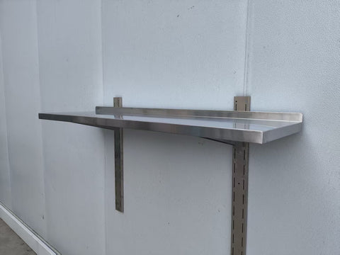 Stainless steel wall-mounted shelf front view

Close-up of shelf bracket and mounting

Side view of stainless steel shelf over prep station

Commercial wall shelf above kitchen counter

Single-tier wall shelf with polished finish