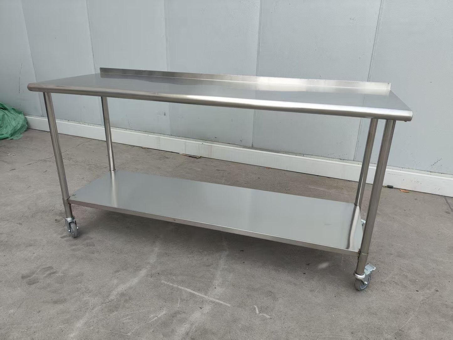 Stainless steel rolling work table with locking wheels – front view

48-inch stainless steel prep station with under-shelf and casters

72-inch commercial kitchen table with wheels – side angle

Mobile food service prep table with heavy-duty design

Industrial stainless table in warehouse environment