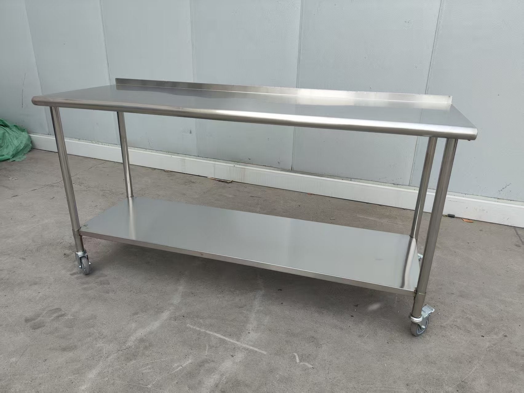 Stainless steel rolling work table with locking wheels – front view

48-inch stainless steel prep station with under-shelf and casters

72-inch commercial kitchen table with wheels – side angle

Mobile food service prep table with heavy-duty design

Industrial stainless table in warehouse environment
