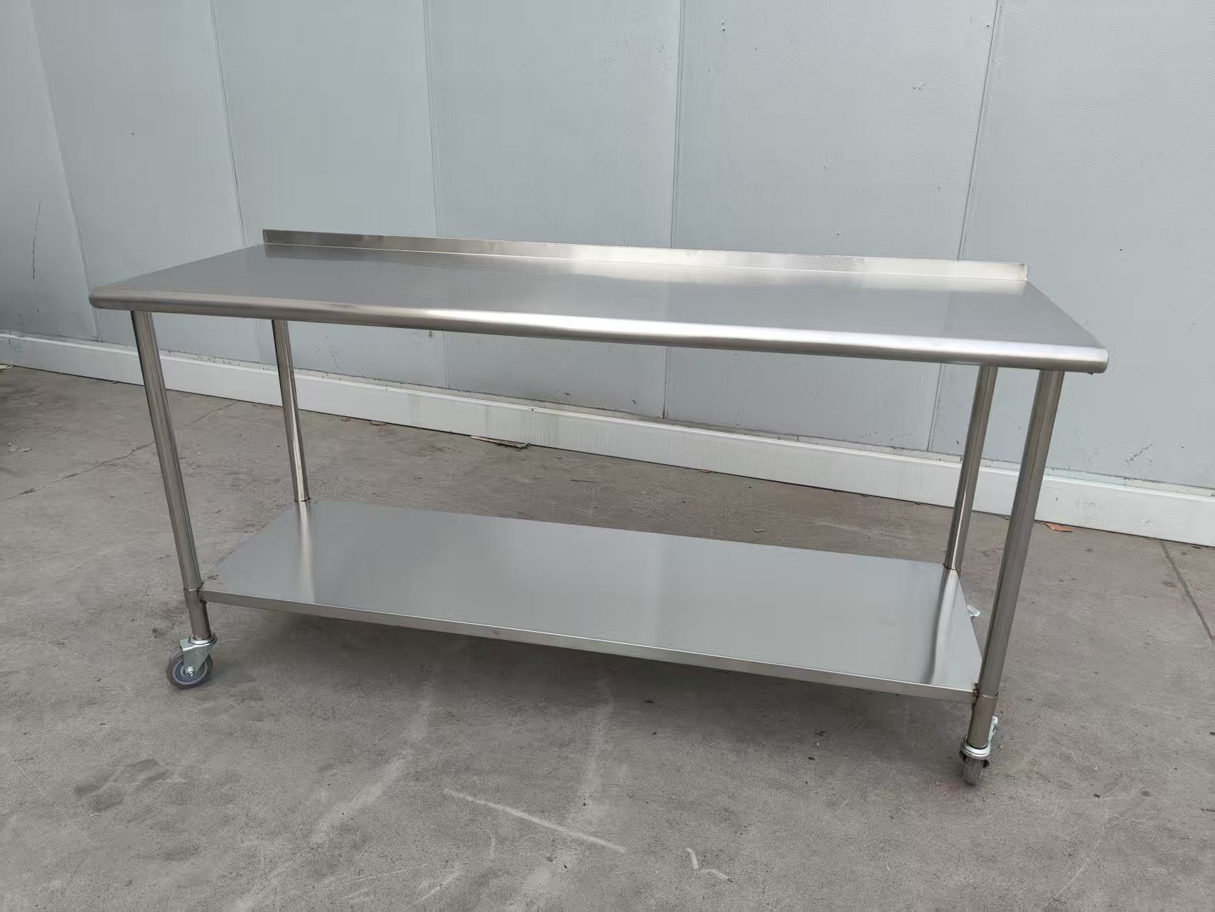 Stainless steel rolling work table with locking wheels – front view

48-inch stainless steel prep station with under-shelf and casters

72-inch commercial kitchen table with wheels – side angle

Mobile food service prep table with heavy-duty design

Industrial stainless table in warehouse environment