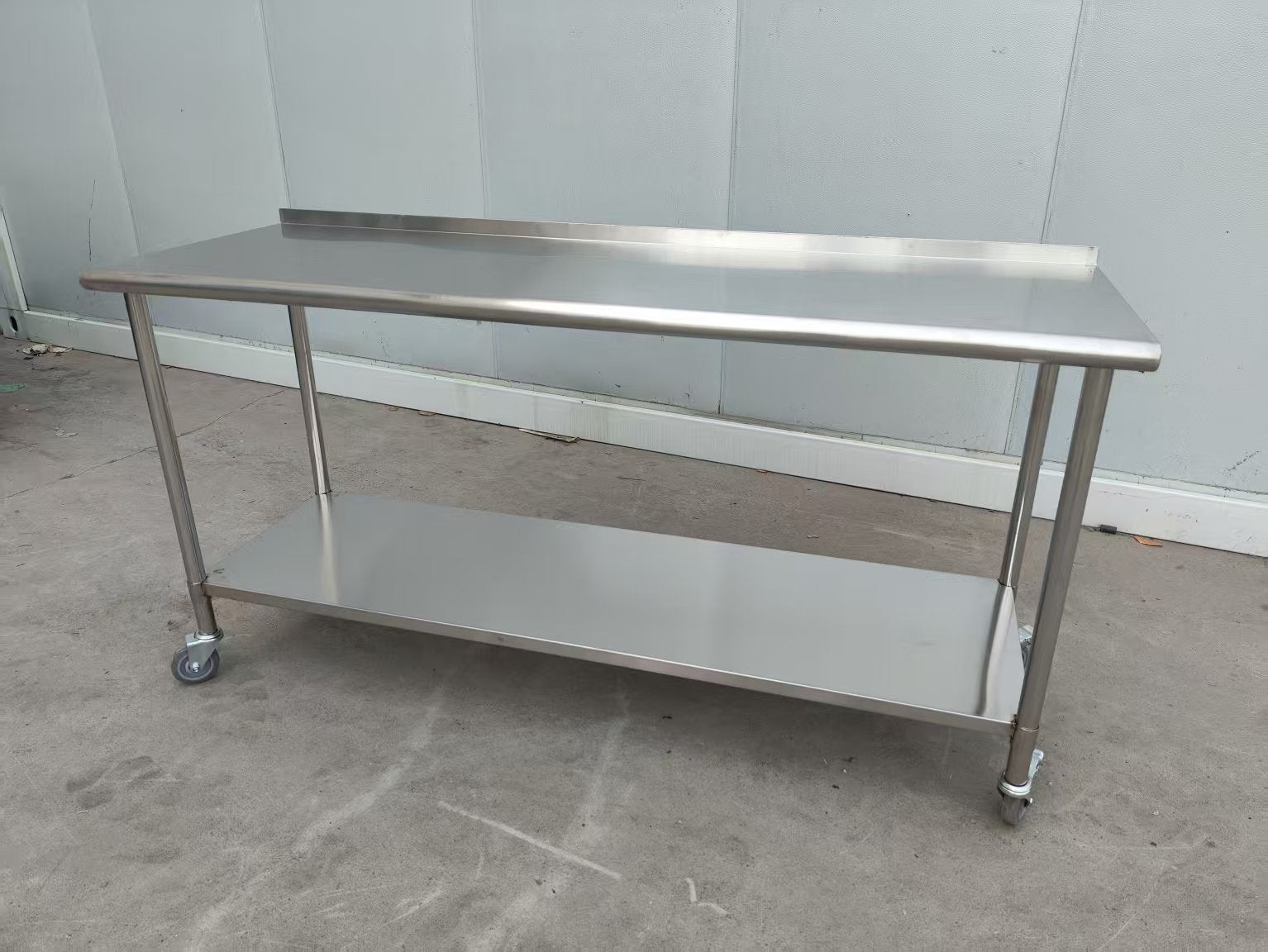 Stainless steel rolling work table with locking wheels – front view

48-inch stainless steel prep station with under-shelf and casters

72-inch commercial kitchen table with wheels – side angle

Mobile food service prep table with heavy-duty design

Industrial stainless table in warehouse environment