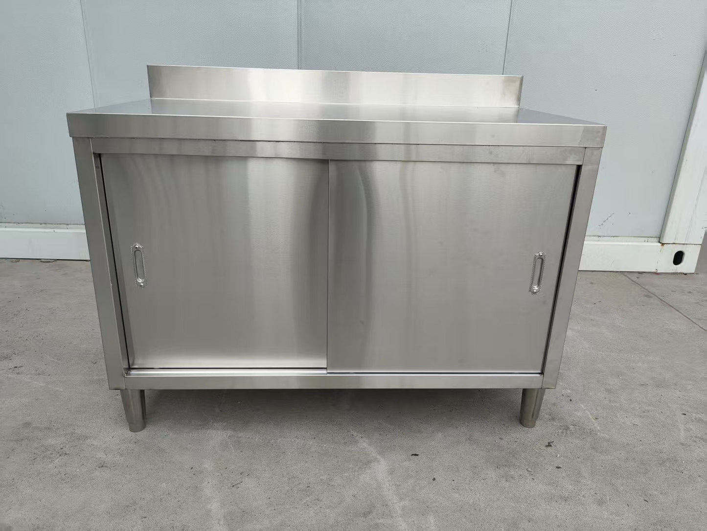 Stainless steel workbench with sliding doors front view

Restaurant prep table with built-in storage

Commercial kitchen stainless steel workbench

Side view of sliding door stainless work table

Heavy-duty garage workbench with stainless cabinet