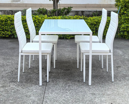 White glass dining table set with 4 chairs in the bright kitchen
Close-up of white glass table and upholstered chair
Side angle of a full 5-piece dining set
White dining chairs around a modern glass table
Dining set outdoors showing full product design