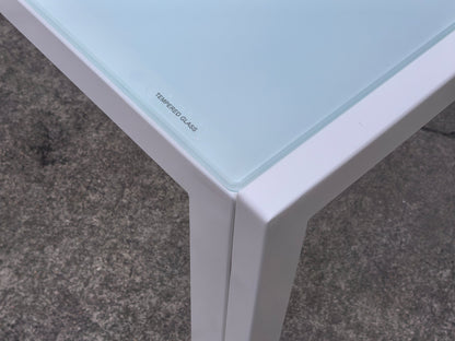 White glass dining table set with 4 chairs in the bright kitchen
Close-up of white glass table and upholstered chair
Side angle of a full 5-piece dining set
White dining chairs around a modern glass table
Dining set outdoors showing full product design