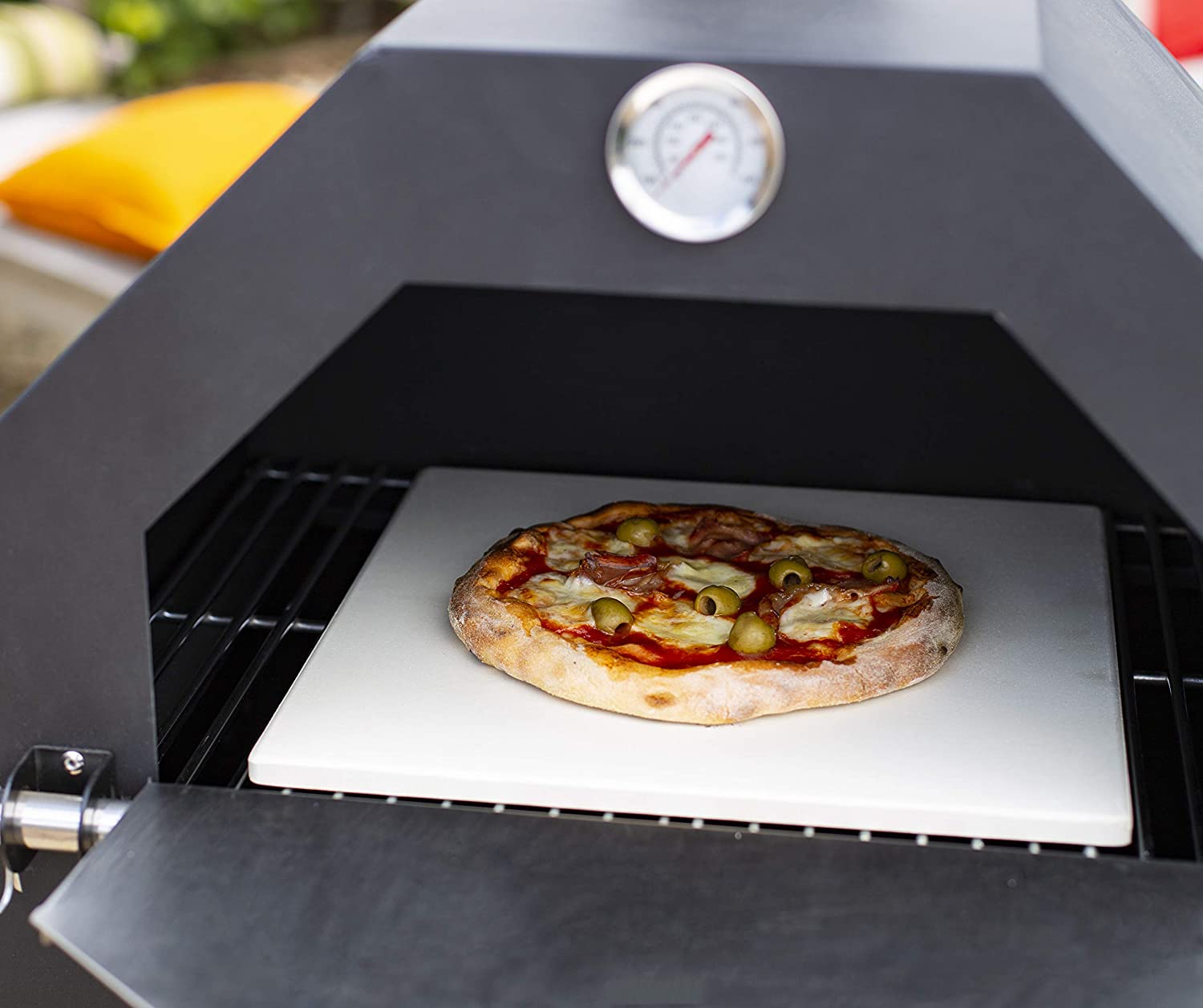 "Stainless steel outdoor pizza oven with chimney and stone insert"

"Dual-fuel pizza oven setup with wood and gas burners"

"Outdoor stainless pizza oven in backyard setting"

"Compact portable pizza oven on patio table"

"Fully cooked pizza inside stainless oven"