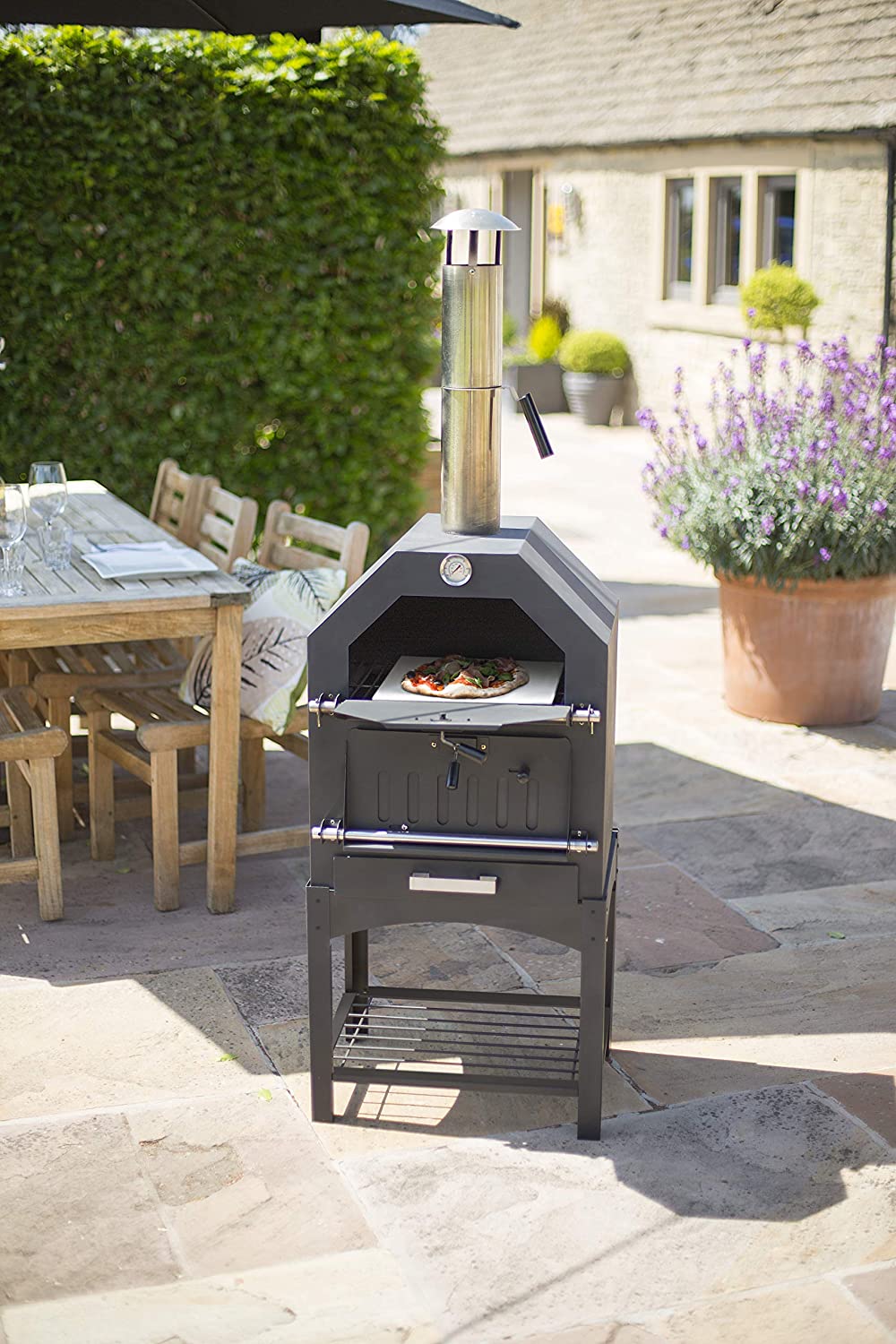 "Stainless steel outdoor pizza oven with chimney and stone insert"

"Dual-fuel pizza oven setup with wood and gas burners"

"Outdoor stainless pizza oven in backyard setting"

"Compact portable pizza oven on patio table"

"Fully cooked pizza inside stainless oven"