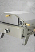 "Stainless steel outdoor pizza oven with chimney and stone insert"

"Dual-fuel pizza oven setup with wood and gas burners"

"Outdoor stainless pizza oven in backyard setting"

"Compact portable pizza oven on patio table"

"Fully cooked pizza inside stainless oven"